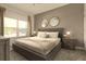 Neutral main bedroom showcasing a large bed, two matching bedside tables and dual round mirrors at 3009 Penelope Loop, Kissimmee, FL 34746