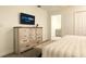 The main bedroom has a comfortable bed and a dresser with a television, perfect for relaxation at 3009 Penelope Loop, Kissimmee, FL 34746