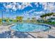 Beautiful community pool featuring clear water, palm trees, lounge chairs and cloudy blue skies at 3009 Penelope Loop, Kissimmee, FL 34746