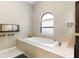 Bright bathroom featuring large bathtub, tiled surround, and window allowing natural light at 324 Old Mill Rd, Enterprise, FL 32725