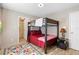 Cozy bedroom with bunk beds, overhead lighting, closet, and colorful rug on light wood floors at 324 Old Mill Rd, Enterprise, FL 32725