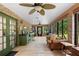 Spacious sunroom with brick accent walls, ceiling fans, a wet bar, and access to the backyard at 324 Old Mill Rd, Enterprise, FL 32725