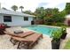 Inviting pool area with lounge chairs, lush greenery, and a charming patio for relaxation at 3317 Dormer Ct, Winter Park, FL 32792