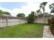 A spacious backyard featuring a well-maintained lawn, privacy fence, and tropical landscaping at 3317 Dormer Ct, Winter Park, FL 32792