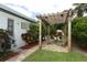 Charming pergola shading an outdoor seating area, with lush greenery and stone pavers at 3317 Dormer Ct, Winter Park, FL 32792