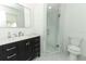 Modern bathroom with a dark vanity, marble countertop, sleek mirror, and glass-enclosed shower at 3317 Dormer Ct, Winter Park, FL 32792