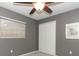 Bedroom with a ceiling fan, window, and double door closet, all set against gray walls at 3317 Dormer Ct, Winter Park, FL 32792