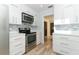 Well-lit kitchen features stainless steel appliances, sleek white cabinets, and stylish backsplash at 3317 Dormer Ct, Winter Park, FL 32792