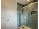 Stylish bathroom featuring a glass-enclosed shower with sleek blue tiles, complemented by a white door and modern fixtures at 3532 Amaca Cir, Orlando, FL 32837