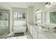 Bright bathroom with double vanity, soaking tub, glass shower, and marble countertops at 3532 Amaca Cir, Orlando, FL 32837