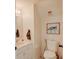 Charming powder room featuring a classic toilet, vanity with sink, and framed turtle art, accented by soft, neutral tones at 3532 Amaca Cir, Orlando, FL 32837