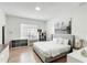 Well-lit bedroom with hardwood floors, a tufted headboard, and a window overlooking the property at 3532 Amaca Cir, Orlando, FL 32837