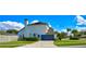Charming two-story home with a blue garage door, solar panels, a well-manicured lawn, and beautiful landscaping at 3532 Amaca Cir, Orlando, FL 32837