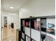 Hallway with hardwood floors and a black shelf displaying books and decorations at 3532 Amaca Cir, Orlando, FL 32837