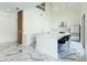 Bright, contemporary kitchen featuring white cabinetry, a large island, and marble floors at 3532 Amaca Cir, Orlando, FL 32837