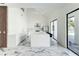 Modern kitchen with white cabinets, a large central island with seating, and sleek marble floors at 3532 Amaca Cir, Orlando, FL 32837