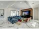 Modern living room with a stylish blue sectional sofa, elegant marble flooring, and a wall-mounted entertainment center at 3532 Amaca Cir, Orlando, FL 32837
