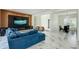 Open-concept living room with a large blue sofa, marble floors, and a view into the adjacent dining area at 3532 Amaca Cir, Orlando, FL 32837