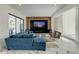 Bright living room featuring a comfortable blue sofa, marble floors, and a contemporary entertainment setup at 3532 Amaca Cir, Orlando, FL 32837