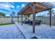 Stylish pergola providing shade for outdoor dining and relaxation with stone pavers and a fenced yard at 3532 Amaca Cir, Orlando, FL 32837