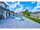 Serene view of a backyard pool with a paver patio, manicured lawn, and a privacy fence, creating a relaxing oasis at 3532 Amaca Cir, Orlando, FL 32837