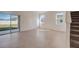 Sunlit living room with tile flooring, sliding glass door, and staircase at 3565 Dahlia Dr, Lake Hamilton, FL 33851