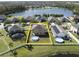 Aerial view of a home's backyard with a white picket fence, green lawn, and swimming pool with a lake nearby at 3680 Ricky Ln, St Cloud, FL 34772