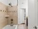 A tiled bathtub and shower area with a showerhead and a tiled design at 4021 Hargill Dr, Orlando, FL 32806