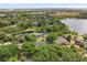 Breathtaking aerial view of a home nestled amidst dense trees and a tranquil pond, offering a private, nature-filled setting at 4065 Winderlakes Dr, Orlando, FL 32835