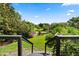 Backyard view from deck featuring lush garden with pond in the distance at 4065 Winderlakes Dr, Orlando, FL 32835