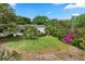 Expansive backyard with lush lawn, mature trees, and exterior view of the home at 4065 Winderlakes Dr, Orlando, FL 32835