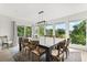 Dining room boasts a large table, chairs, modern lighting, and picturesque views through expansive windows at 4065 Winderlakes Dr, Orlando, FL 32835