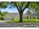Charming single-story home showcasing a well-maintained lawn and mature tree in a suburban neighborhood setting at 4065 Winderlakes Dr, Orlando, FL 32835