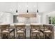 Bright kitchen features a large marble island, modern pendant lighting and seating for four at 4065 Winderlakes Dr, Orlando, FL 32835