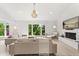 Bright living room with a brick fireplace, light wood floors, neutral furniture, and a large window overlooking nature at 4065 Winderlakes Dr, Orlando, FL 32835