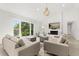 Open concept living room with a large window, neutral furniture, a brick fireplace, and light wood floors at 4065 Winderlakes Dr, Orlando, FL 32835