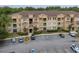 Wide aerial shot shows the building, parking lot, landscaping, and surrounding wooded area of the condo complex at 419 Terrace Ridge Cir # 419, Davenport, FL 33896
