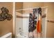 Bathroom features a shower-tub combination, white tile, and a decorative shower curtain with tropical accents at 419 Terrace Ridge Cir # 419, Davenport, FL 33896