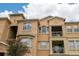 Upward angle of a peach colored, multi-story condo with a balcony at 419 Terrace Ridge Cir # 419, Davenport, FL 33896