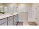 This bathroom features a frameless glass shower, white subway tile, and gray cabinetry at 4191 Holstein St, St Cloud, FL 34772