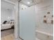 View of a bright bathroom featuring glass enclosed shower and primary suite with modern decor in the background at 4509 Patricia Ann Ct, Orlando, FL 32839
