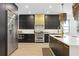 Spacious kitchen with black cabinets, stainless steel appliances, and center island with pendant lights at 4509 Patricia Ann Ct, Orlando, FL 32839