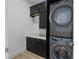 Laundry room featuring stacked washer and dryer, stylish cabinets, and quartz countertops at 4509 Patricia Ann Ct, Orlando, FL 32839