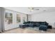 Bright living room with large windows, neutral walls, wood-style floors and a comfortable blue sectional sofa at 4509 Patricia Ann Ct, Orlando, FL 32839