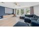 Living room featuring projector screen, media center, and a comfortable sectional sofa by three large windows at 4509 Patricia Ann Ct, Orlando, FL 32839