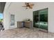 Outdoor kitchen on a stone patio with a grill and sliding doors at 4509 Patricia Ann Ct, Orlando, FL 32839
