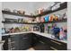 Walk-in pantry featuring sleek black cabinetry, quartz countertops, and ample shelving for storage at 4509 Patricia Ann Ct, Orlando, FL 32839