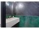 Stylish powder room featuring a floating sink, gold hardware, and unique emerald green tile at 4509 Patricia Ann Ct, Orlando, FL 32839
