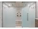 This luxurious shower boasts dual shower heads, bench seating, and frosted glass doors at 4509 Patricia Ann Ct, Orlando, FL 32839