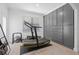 This well-lit workout area features gray built-in cabinets for ample storage and a treadmill at 4509 Patricia Ann Ct, Orlando, FL 32839